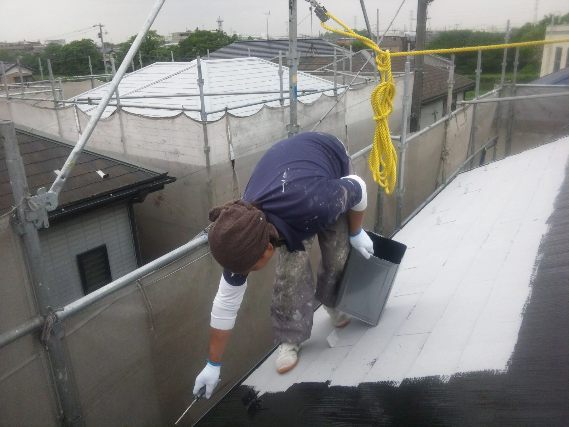 屋根上塗り１回目（左奥に見える白い屋根は下塗りの状態です）